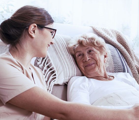 Caregiver and elderly woman sitting on couch | Respite care services | Neighborly Home Care