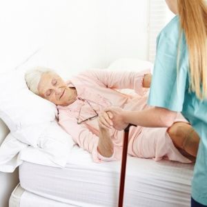 Caregiver helping elderly woman out of bed | Neighborly Home Care offers best elder care services near me, in Pennsylvania and Delaware