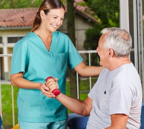 Senior and caregiver helping him exercise | senior care services | Neighborly Home Care