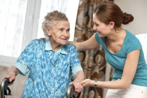Caregiver helps senior woman with walker | Home Care Specialists | Neighborly Home Care