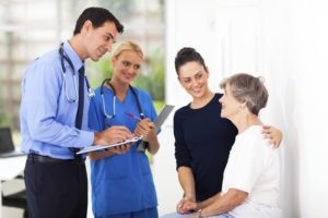 Doctor and nurse talking to elderly woman with caretaker | elderly care for loved ones | Neighborly Home Care