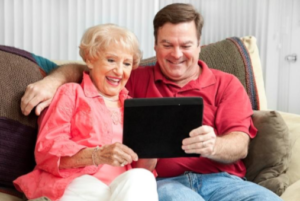 senior woman and son looking at tablet together | Neighborly Home Care, Bryn Mawr Home Care Provider discusses long-distance senior care 