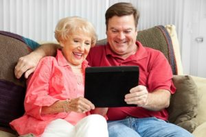 Mother and son looking at tablet on couch | Home Care for an Aging Parent | Neighborly Home Care