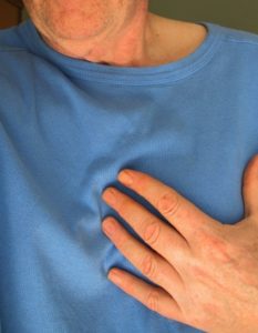 Person holding his chest - American Heart Month - Neighborly Home CareSenior Home Care Agency Advises Heart Attack Symptom Awareness