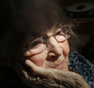 Elderly woman looking out window | exploring dementia | Neighborly Home Care