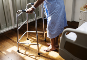 Senior person with walker standing near bed | effects of the pandemic on caregivers | Neighborly Home Care