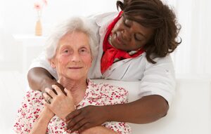 Senior woman with caregiver hugging | exploring dementia | Neighborly Home Care